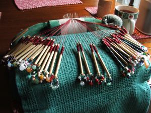 Lace pillow with pricking, pins, and bobbins